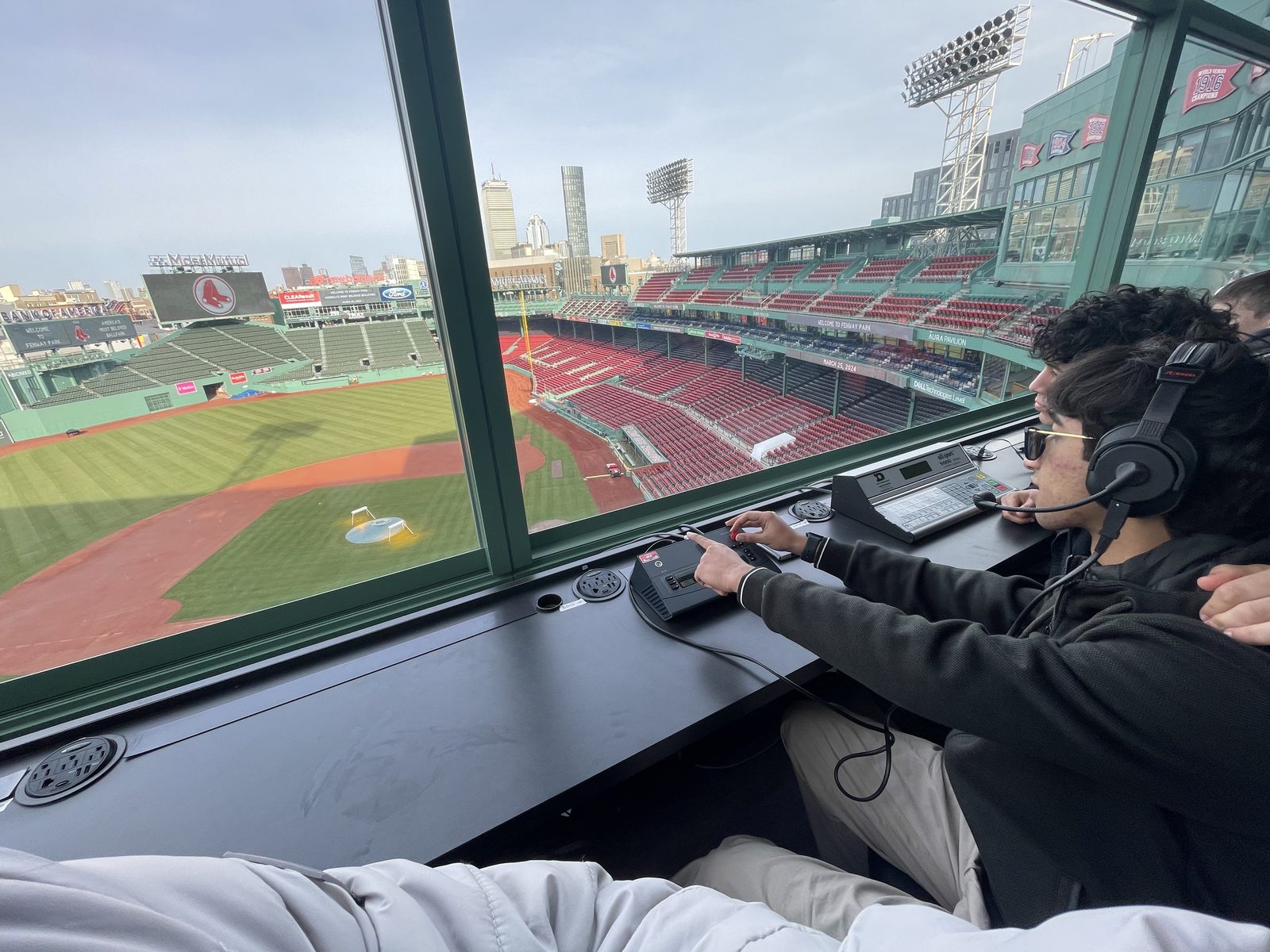 Looking out over an empty Fenway Park from the press box, someone at the sound desk in headphones